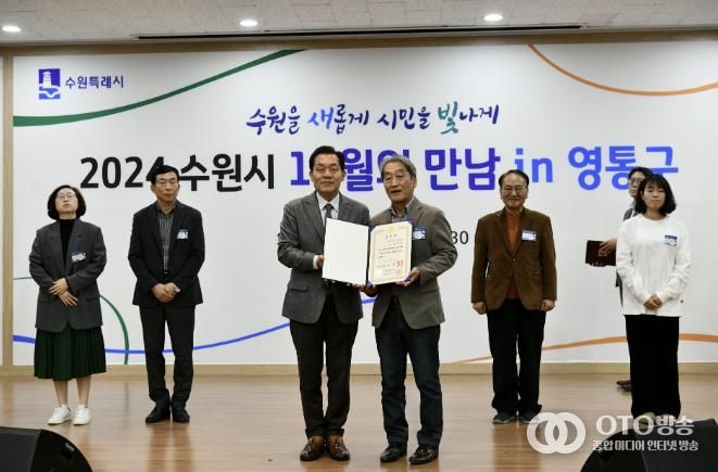 이재준 수원시장(왼쪽)과 송재등 전 매탄3동 주민자치회장이 표창장 전수 후 함께 하고 있다.