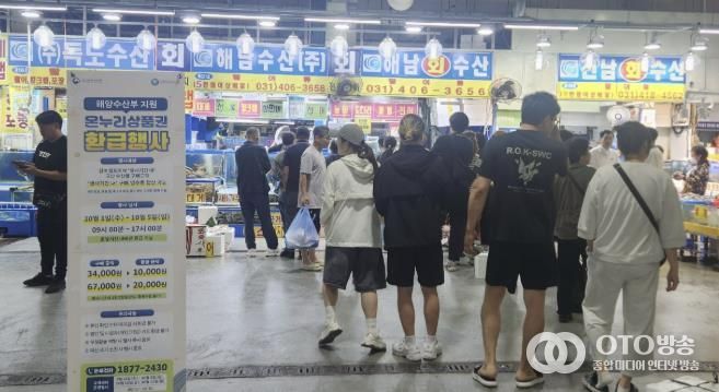 시민들이 안산시농수산물도매시장에서 '온누리상품권 환급행사'에 참여하기 위해 줄지어 서있다.