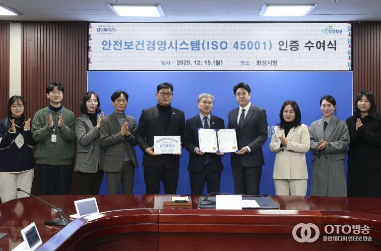 정구원 화성특례시 제1부시장 및 안상현 ISO 45001 선임 심사원 등 관계자가 안전보건경영시스템 인증식에서 기념 촬영을 하고 있다