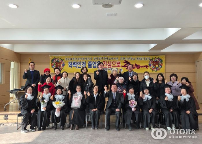 졸업생(의왕시민학교, 의왕시청)들이 학사모를 쓰고 환하게 웃으며 단체 기념사진을 촬영하고 있다.
